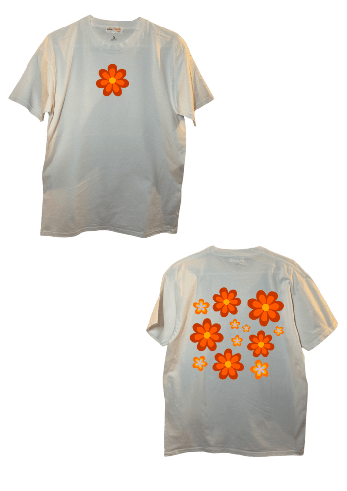 T-shirt oversize blanc, manche courte, 100% coton. Personnalisation du t-shirt grâce à une technique de flocage, le DTF, pour une meilleure qualité d’impression et de tenue. La personnalisation est floquée à l’avant au milieu en haut et à l’arrière en grand dans le dos. Ici, il s’agit de la personnalisation de DTF fleur orange style années 70.