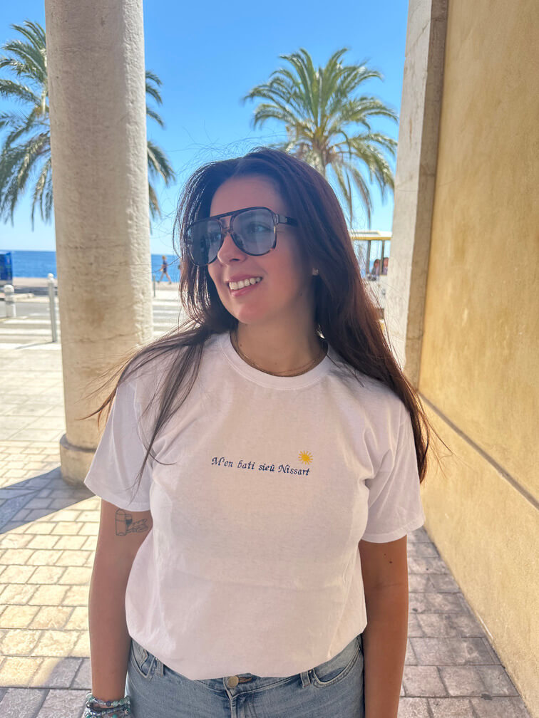 T-shirt oversize blanc, 100% coton. Personnalisation du t-shirt grâce à des broderies. Il faut choisir parmi un choix de broderies dessinées à la main sur le thème de l’été sur la Côte d’Azur dans les Alpes Maritimes, 06. Toutes les broderies sont faites à la commande selon la personnalisation choisie. Ici, il s’agit de la broderie "m'en bati sieu Nissart" pour tous les niçois niçoises Nice