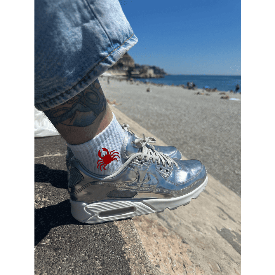 Chaussette brodée broderie personnalisation crabe rouge sur le côté porté par un homme devant la plage