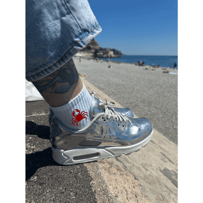 Chaussette brodée broderie personnalisation crabe rouge sur le côté porté par un homme devant la plage
