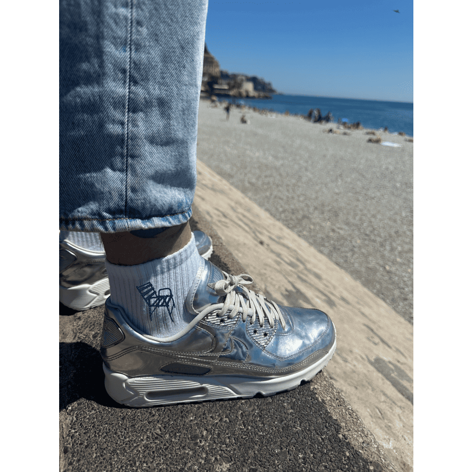 Chaussette brodée broderie portée par un homme avec une personnalisation brodée chaise bleue sur le côté de la chaussette promenade des anglais nice 06