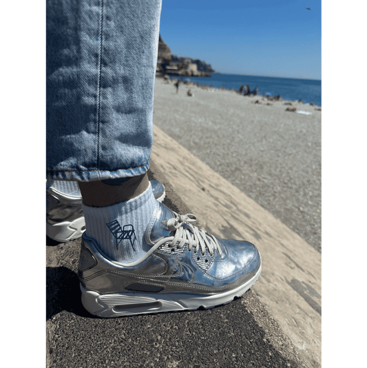 Chaussette brodée broderie portée par un homme avec une personnalisation brodée chaise bleue sur le côté de la chaussette promenade des anglais nice 06