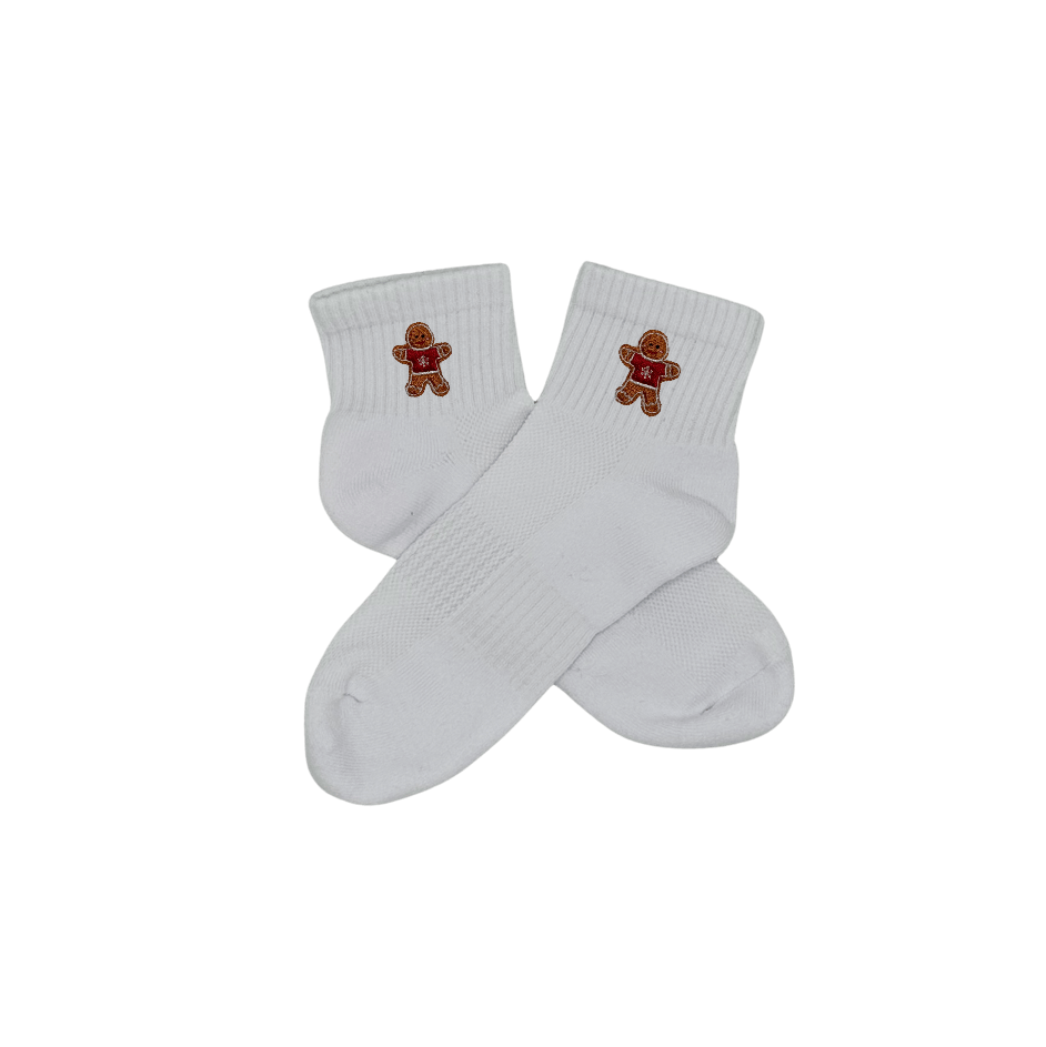 Chaussettes blanches courtes, 100% coton. Personnalisation des chaussettes grâce à des broderies. Il faut choisir parmi un choix de broderies dessinées à la main sur le thème de l’hiver, Noël, fêtes fin d’année, winter. La broderie est présente sur le côté extérieur des chaussettes. Toutes les broderies sont faites à la commande selon la personnalisation choisie. Ici, il s’agit de la broderie bonhomme en pain d'épices