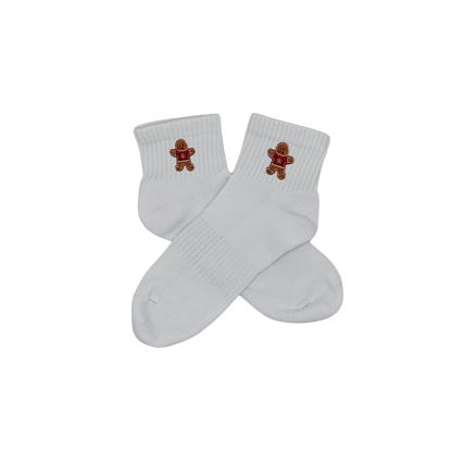 Chaussettes blanches courtes, 100% coton. Personnalisation des chaussettes grâce à des broderies. Il faut choisir parmi un choix de broderies dessinées à la main sur le thème de l’hiver, Noël, fêtes fin d’année, winter. La broderie est présente sur le côté extérieur des chaussettes. Toutes les broderies sont faites à la commande selon la personnalisation choisie. Ici, il s’agit de la broderie bonhomme en pain d'épices