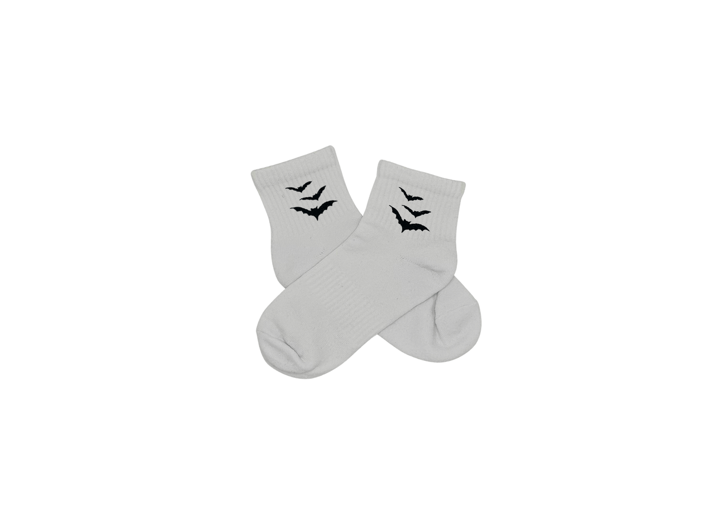 Chaussettes blanches courtes, 100% coton. Personnalisation des chaussettes grâce à des broderies. Il faut choisir parmi un choix de broderies dessinées à la main sur le thème de l’automne, saison automnale, Halloween, broderie cosy. La broderie est présente sur le côté extérieur des chaussettes. Toutes les broderies sont faites à la commande selon la personnalisation choisie. Ici, il s’agit de la broderie chauve-souris, noir.