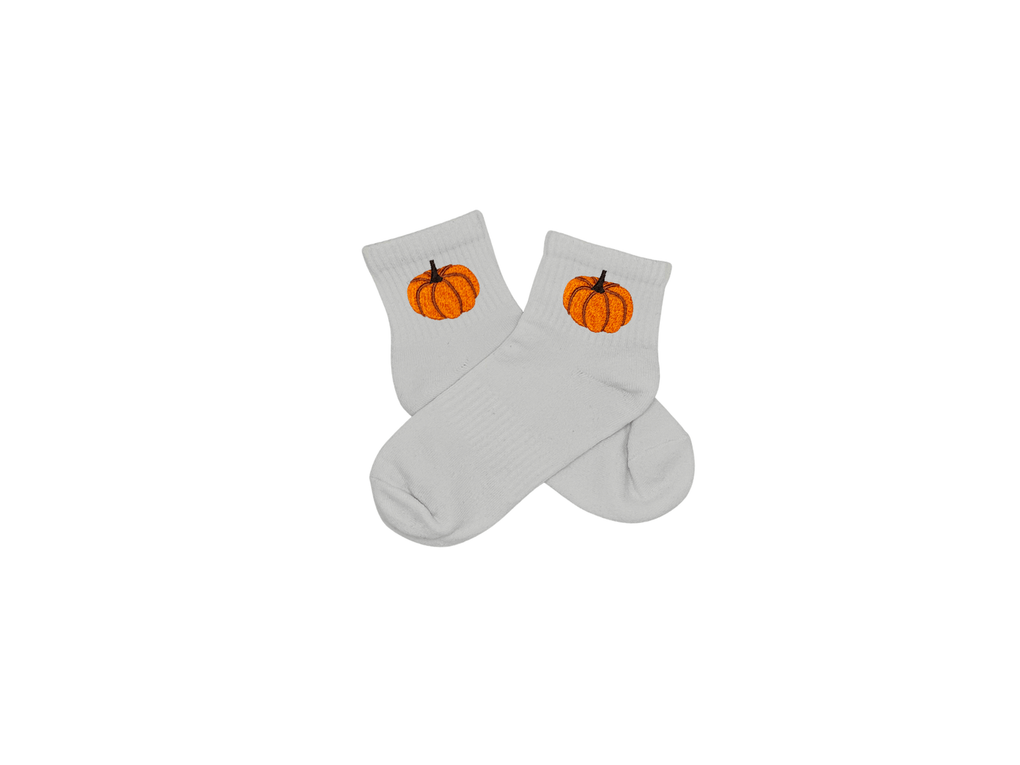 Chaussettes blanches courtes, 100% coton. Personnalisation des chaussettes grâce à des broderies. Il faut choisir parmi un choix de broderies dessinées à la main sur le thème de l’automne, saison automnale, Halloween, broderie cosy. La broderie est présente sur le côté extérieur des chaussettes. Toutes les broderies sont faites à la commande selon la personnalisation choisie. Ici, il s’agit de la broderie citrouille, orange.
