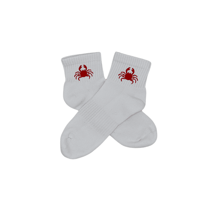 Chaussettes blanches courtes, 100% coton. Personnalisation des chaussettes grâce à des broderies. Il faut choisir parmi un choix de broderies dessinées à la main sur le thème de l’été sur la Côte d’Azur dans les Alpes Maritimes, 06. La broderie est présente sur le côté extérieur des chaussettes. Toutes les broderies sont faites à la commande selon la personnalisation choisie. Ici, il s’agit de la broderie crabe, rouge.