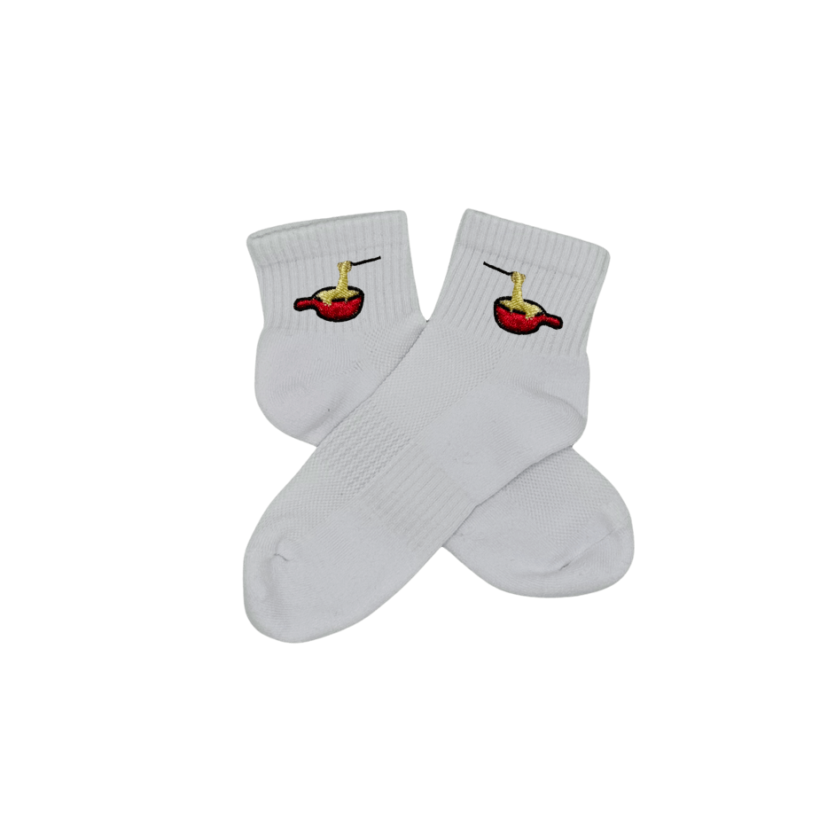 Chaussettes blanches courtes, 100% coton. Personnalisation des chaussettes grâce à des broderies. Il faut choisir parmi un choix de broderies dessinées à la main sur le thème de l’hiver, Noël, fêtes fin d’année, winter. La broderie est présente sur le côté extérieur des chaussettes. Toutes les broderies sont faites à la commande selon la personnalisation choisie. Ici, il s’agit de la broderie fondue savoyarde fromage fondu
