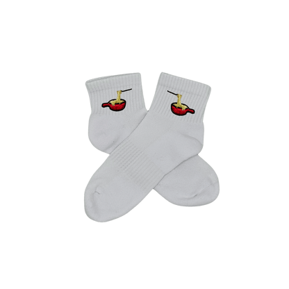 Chaussettes blanches courtes, 100% coton. Personnalisation des chaussettes grâce à des broderies. Il faut choisir parmi un choix de broderies dessinées à la main sur le thème de l’hiver, Noël, fêtes fin d’année, winter. La broderie est présente sur le côté extérieur des chaussettes. Toutes les broderies sont faites à la commande selon la personnalisation choisie. Ici, il s’agit de la broderie fondue savoyarde fromage fondu