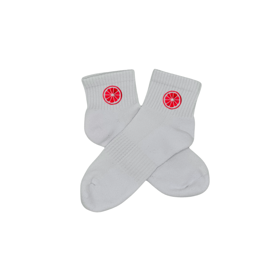 Chaussettes blanches courtes, 100% coton. Personnalisation des chaussettes grâce à des broderies. Il faut choisir parmi un choix de broderies dessinées à la main sur le thème de l’été sur la Côte d’Azur dans les Alpes Maritimes, 06. La broderie est présente sur le côté extérieur des chaussettes. Toutes les broderies sont faites à la commande selon la personnalisation choisie. Ici, il s’agit de la broderie pomelo, pamplemousse, agrume, rose flashy.