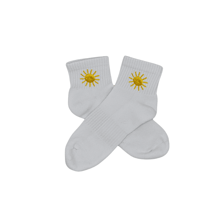 Chaussettes blanches courtes, 100% coton. Personnalisation des chaussettes grâce à des broderies. Il faut choisir parmi un choix de broderies dessinées à la main sur le thème de l’été sur la Côte d’Azur dans les Alpes Maritimes, 06. La broderie est présente sur le côté extérieur des chaussettes. Toutes les broderies sont faites à la commande selon la personnalisation choisie. Ici, il s’agit de la broderie soleil, jaune. 