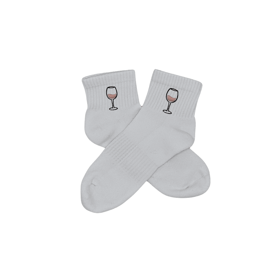 Chaussettes blanches courtes, 100% coton. Personnalisation des chaussettes grâce à des broderies. Il faut choisir parmi un choix de broderies dessinées à la main sur le thème de l’été sur la Côte d’Azur dans les Alpes Maritimes, 06. La broderie est présente sur le côté extérieur des chaussettes. Toutes les broderies sont faites à la commande selon la personnalisation choisie. Ici, il s’agit de la broderie verre de vin rosé, rose clair et noir.