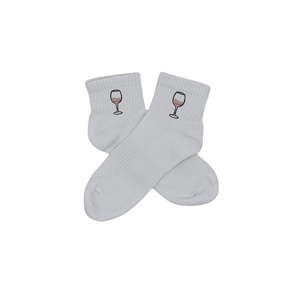 Chaussettes blanches courtes, 100% coton. Personnalisation des chaussettes grâce à des broderies. Il faut choisir parmi un choix de broderies dessinées à la main sur le thème de l’été sur la Côte d’Azur dans les Alpes Maritimes, 06. La broderie est présente sur le côté extérieur des chaussettes. Toutes les broderies sont faites à la commande selon la personnalisation choisie. Ici, il s’agit de la broderie verre de vin rosé, rose clair et noir.