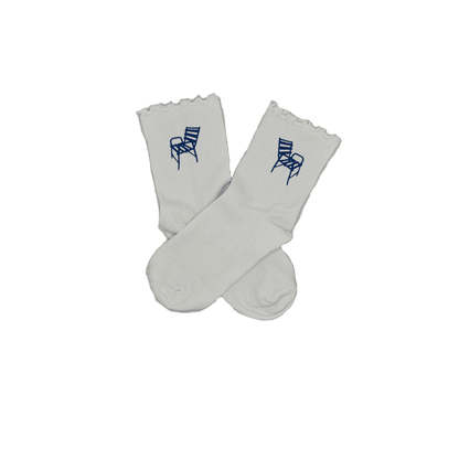Chaussettes blanches courtes avec petits froufrous à l’extrémité, 100% coton. Personnalisation des chaussettes grâce à des broderies. Il faut choisir parmi un choix de broderies dessinées à la main sur le thème de l’été sur la Côte d’Azur dans les Alpes Maritimes, 06. La broderie est présente sur le côté extérieur des chaussettes. Toutes les broderies sont faites à la commande selon la personnalisation choisie. Ici, il s’agit de la broderie chaise bleue, emblème de la ville de Nice. 