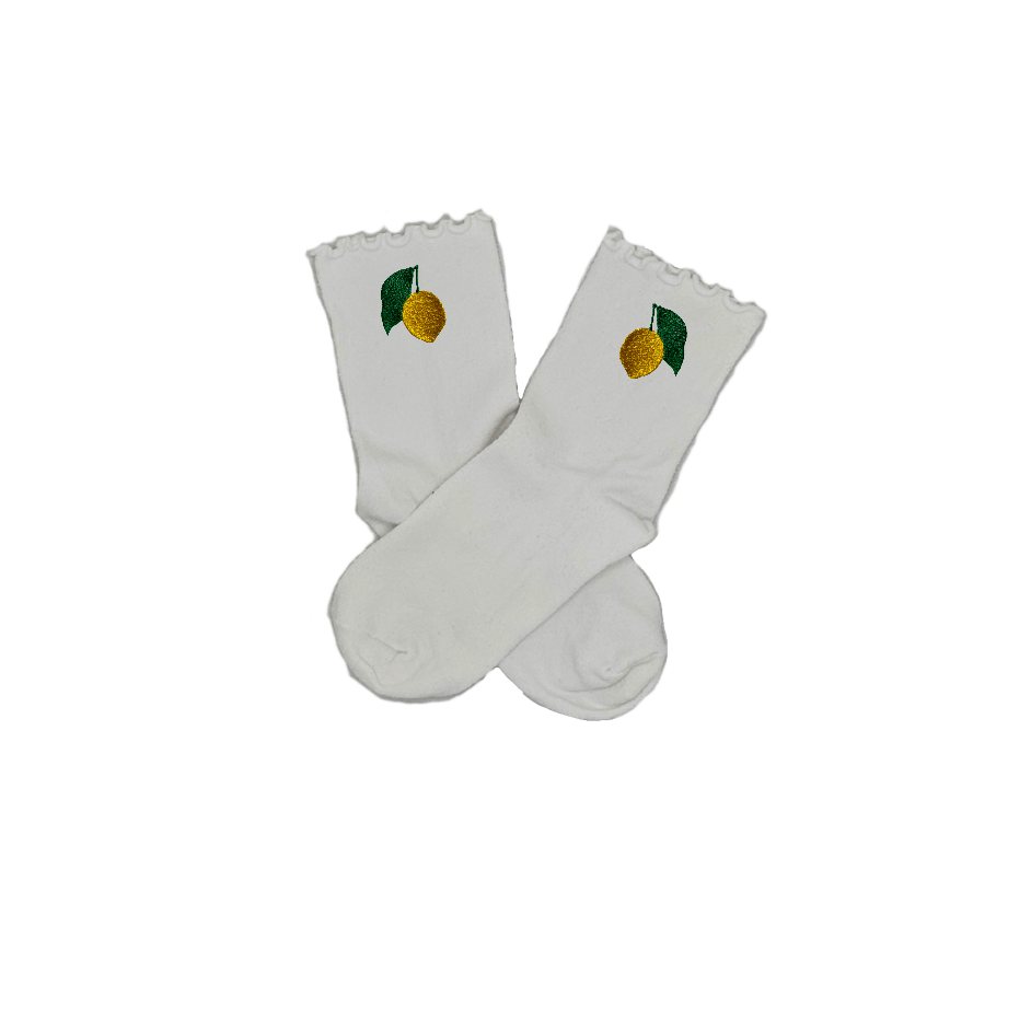 Chaussettes blanches courtes avec petits froufrous à l’extrémité, 100% coton. Personnalisation des chaussettes grâce à des broderies. Il faut choisir parmi un choix de broderies dessinées à la main sur le thème de l’été sur la Côte d’Azur dans les Alpes Maritimes, 06. La broderie est présente sur le côté extérieur des chaussettes. Toutes les broderies sont faites à la commande selon la personnalisation choisie. Ici, il s’agit de la broderie citron de Menton, jaune et vert. Emblème de la ville de Menton.