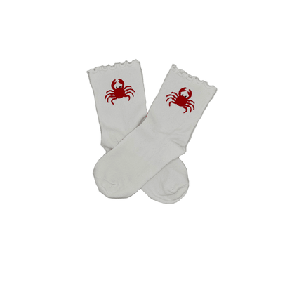 Chaussettes blanches courtes avec petits froufrous à l’extrémité, 100% coton. Personnalisation des chaussettes grâce à des broderies. Il faut choisir parmi un choix de broderies dessinées à la main sur le thème de l’été sur la Côte d’Azur dans les Alpes Maritimes, 06. La broderie est présente sur le côté extérieur des chaussettes. Toutes les broderies sont faites à la commande selon la personnalisation choisie. Ici, il s’agit de la broderie crabe, rouge. 