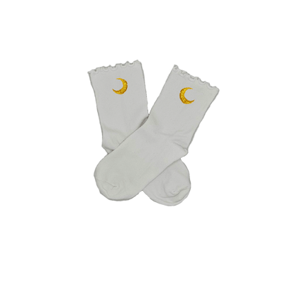 Chaussettes blanches courtes avec petits froufrous à l’extrémité, 100% coton. Personnalisation des chaussettes grâce à des broderies. Il faut choisir parmi un choix de broderies dessinées à la main sur le thème de l’été sur la Côte d’Azur dans les Alpes Maritimes, 06. La broderie est présente sur le côté extérieur des chaussettes. Toutes les broderies sont faites à la commande selon la personnalisation choisie. Ici, il s’agit de la broderie lune, jaune.