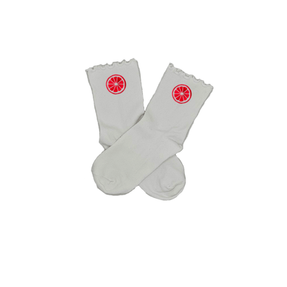 Chaussettes blanches courtes avec petits froufrous à l’extrémité, 100% coton. Personnalisation des chaussettes grâce à des broderies. Il faut choisir parmi un choix de broderies dessinées à la main sur le thème de l’été sur la Côte d’Azur dans les Alpes Maritimes, 06. La broderie est présente sur le côté extérieur des chaussettes. Toutes les broderies sont faites à la commande selon la personnalisation choisie. Ici, il s’agit de la broderie pomelo, pamplemousse, agrume, rose flashy. 
