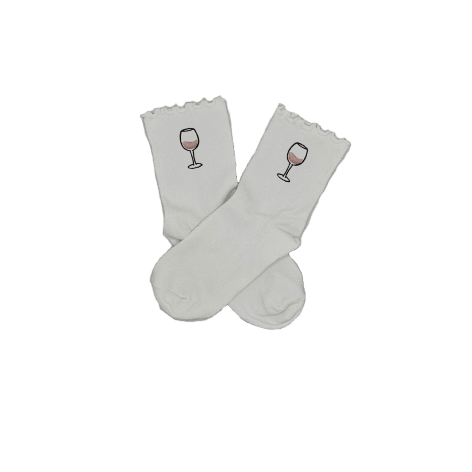 Chaussettes blanches courtes avec petits froufrous à l’extrémité, 100% coton. Personnalisation des chaussettes grâce à des broderies. Il faut choisir parmi un choix de broderies dessinées à la main sur le thème de l’été sur la Côte d’Azur dans les Alpes Maritimes, 06. La broderie est présente sur le côté extérieur des chaussettes. Toutes les broderies sont faites à la commande selon la personnalisation choisie. Ici, il s’agit de la broderie verre de vin rosé, rose clair et noir. 