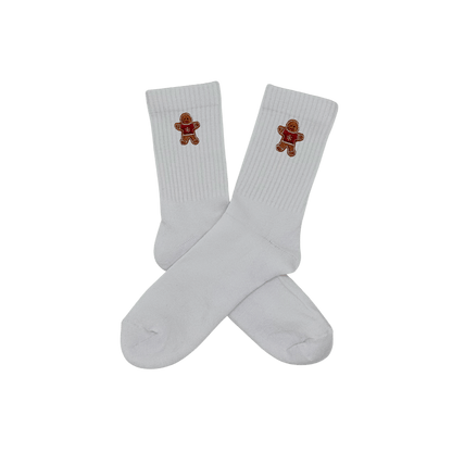 Chaussettes blanches hautes, 100% coton. Personnalisation des chaussettes grâce à des broderies. Il faut choisir parmi un choix de broderies dessinées à la main sur le thème de l’hiver, Noël, fêtes fin d’année, winter. La broderie est présente sur le côté extérieur des chaussettes. Toutes les broderies sont faites à la commande selon la personnalisation choisie. Ici, il s’agit de la broderie bonhomme en pain d'épices