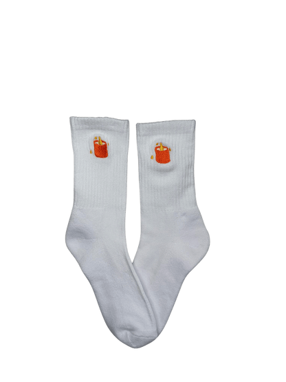 Chaussettes blanches hautes, 100% coton. Personnalisation des chaussettes grâce à des broderies. Il faut choisir parmi un choix de broderies dessinées à la main sur le thème de l’automne, saison automnale, Halloween, broderie cosy. La broderie est présente sur le côté extérieur des chaussettes. Toutes les broderies sont faites à la commande selon la personnalisation choisie. Ici, il s’agit de la broderie bougie orange.