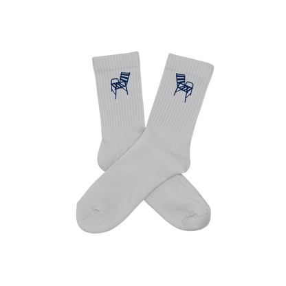 Chaussettes blanches hautes, 100% coton. Personnalisation des chaussettes grâce à des broderies. Il faut choisir parmi un choix de broderies dessinées à la main sur le thème de l’été sur la Côte d’Azur dans les Alpes Maritimes, 06. La broderie est présente sur le côté extérieur des chaussettes. Toutes les broderies sont faites à la commande selon la personnalisation choisie. Ici, il s’agit de la broderie chaise bleue, emblème de la ville de Nice.