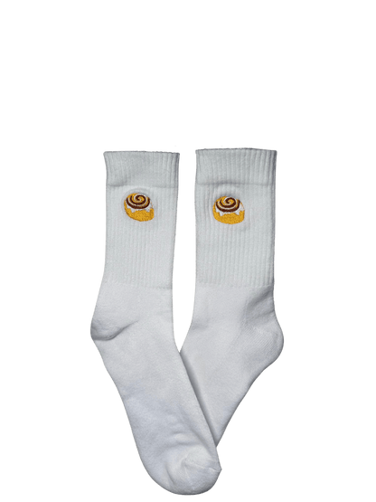 Chaussettes blanches hautes, 100% coton. Personnalisation des chaussettes grâce à des broderies. Il faut choisir parmi un choix de broderies dessinées à la main sur le thème de l’automne, saison automnale, Halloween, broderie cosy. La broderie est présente sur le côté extérieur des chaussettes. Toutes les broderies sont faites à la commande selon la personnalisation choisie. Ici, il s’agit de la broderie cinnamon roll, patisserie, orange, blanc et marron.