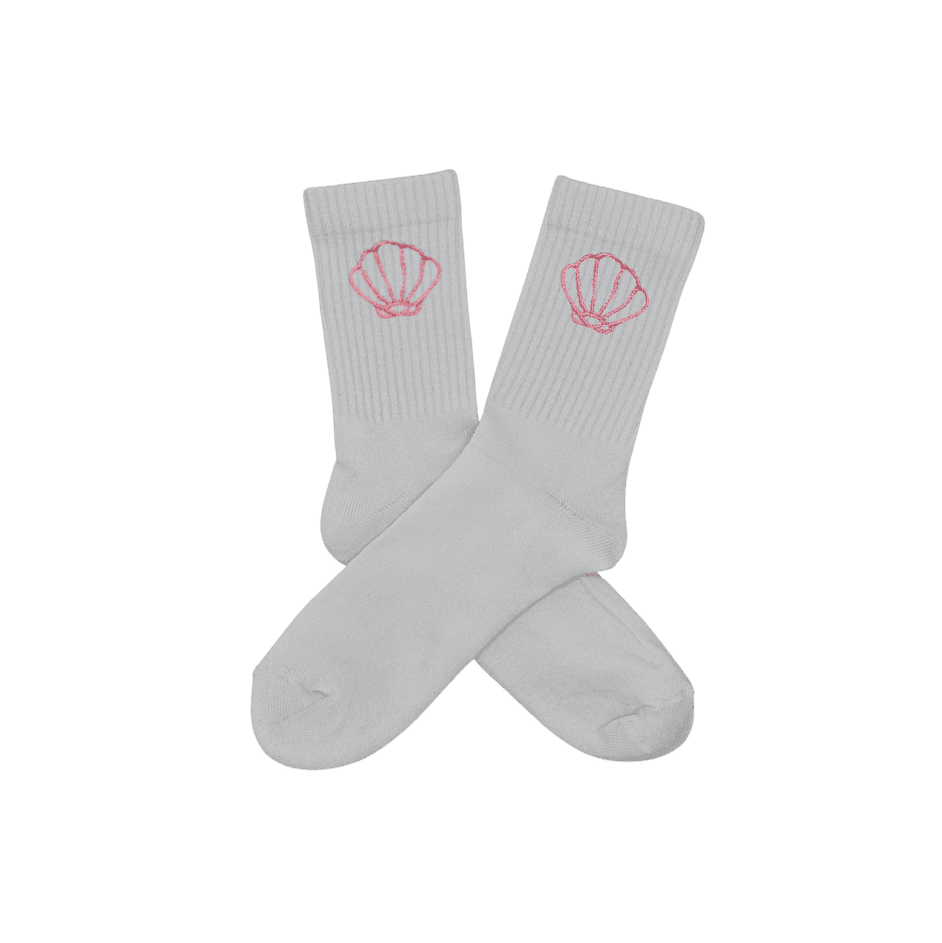 Chaussettes blanches hautes, 100% coton. Personnalisation des chaussettes grâce à des broderies. Il faut choisir parmi un choix de broderies dessinées à la main sur le thème de l’été sur la Côte d’Azur dans les Alpes Maritimes, 06. La broderie est présente sur le côté extérieur des chaussettes. Toutes les broderies sont faites à la commande selon la personnalisation choisie. Ici, il s’agit de la broderie coquillage rose clair.