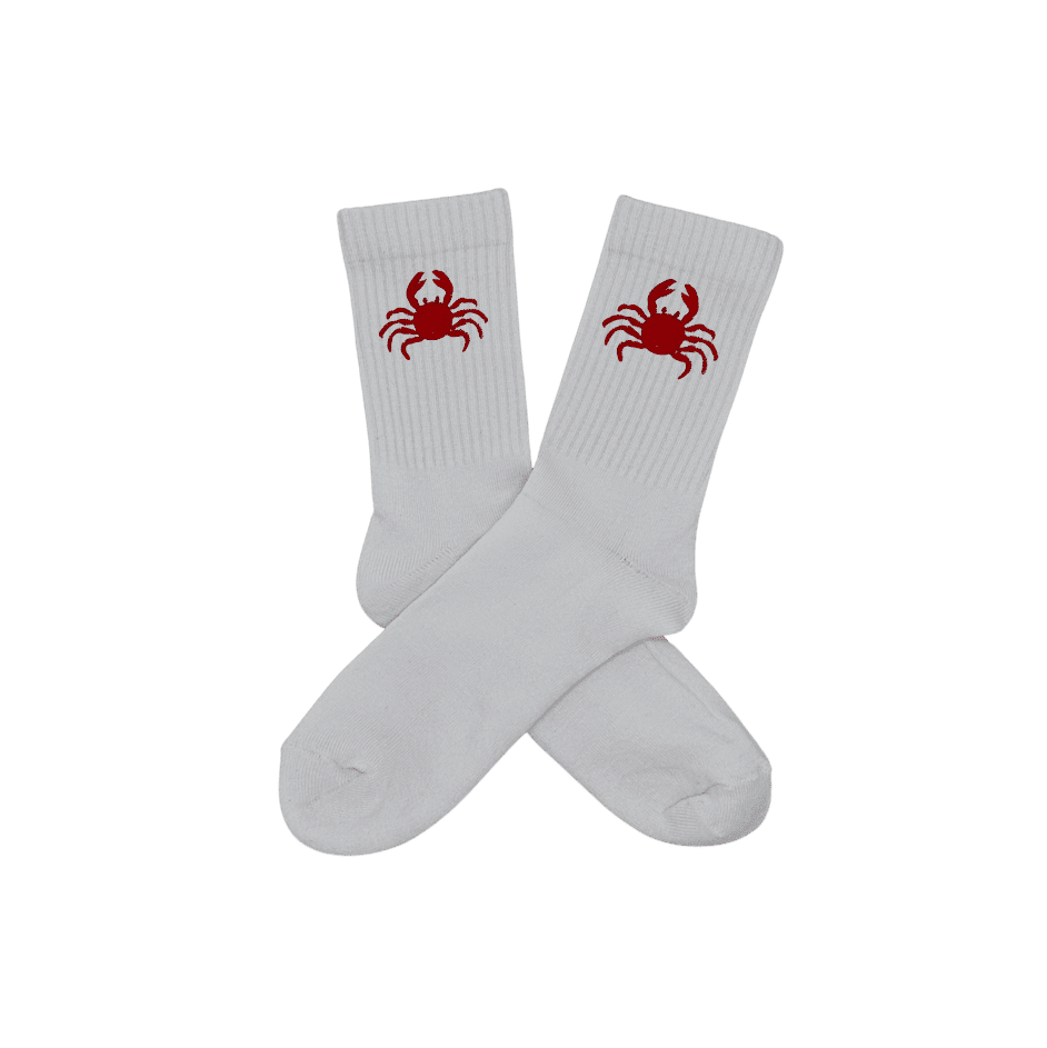 Chaussettes blanches hautes, 100% coton. Personnalisation des chaussettes grâce à des broderies. Il faut choisir parmi un choix de broderies dessinées à la main sur le thème de l’été sur la Côte d’Azur dans les Alpes Maritimes, 06. La broderie est présente sur le côté extérieur des chaussettes. Toutes les broderies sont faites à la commande selon la personnalisation choisie. Ici, il s’agit de la broderie crabe, rouge.