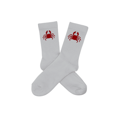 Chaussettes blanches hautes, 100% coton. Personnalisation des chaussettes grâce à des broderies. Il faut choisir parmi un choix de broderies dessinées à la main sur le thème de l’été sur la Côte d’Azur dans les Alpes Maritimes, 06. La broderie est présente sur le côté extérieur des chaussettes. Toutes les broderies sont faites à la commande selon la personnalisation choisie. Ici, il s’agit de la broderie crabe, rouge.
