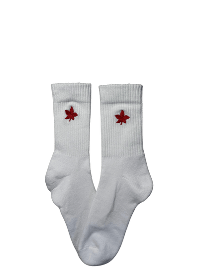 Chaussettes blanches hautes, 100% coton. Personnalisation des chaussettes grâce à des broderies. Il faut choisir parmi un choix de broderies dessinées à la main sur le thème de l’automne, saison automnale, Halloween, broderie cosy. La broderie est présente sur le côté extérieur des chaussettes. Toutes les broderies sont faites à la commande selon la personnalisation choisie. Ici, il s’agit de la broderie feuille rouge.