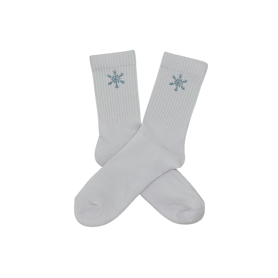 Chaussettes blanches hautes, 100% coton. Personnalisation des chaussettes grâce à des broderies. Il faut choisir parmi un choix de broderies dessinées à la main sur le thème de l’hiver, Noël, fêtes fin d’année, winter. La broderie est présente sur le côté extérieur des chaussettes. Toutes les broderies sont faites à la commande selon la personnalisation choisie. Ici, il s’agit de la broderie flocon