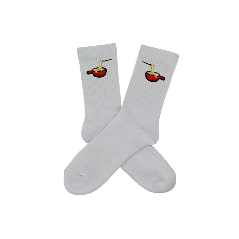 Chaussettes blanches hautes, 100% coton. Personnalisation des chaussettes grâce à des broderies. Il faut choisir parmi un choix de broderies dessinées à la main sur le thème de l’hiver, Noël, fêtes fin d’année, winter. La broderie est présente sur le côté extérieur des chaussettes. Toutes les broderies sont faites à la commande selon la personnalisation choisie. Ici, il s’agit de la broderie fondue savoyarde fromage fondu