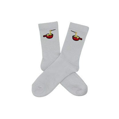 Chaussettes blanches hautes, 100% coton. Personnalisation des chaussettes grâce à des broderies. Il faut choisir parmi un choix de broderies dessinées à la main sur le thème de l’hiver, Noël, fêtes fin d’année, winter. La broderie est présente sur le côté extérieur des chaussettes. Toutes les broderies sont faites à la commande selon la personnalisation choisie. Ici, il s’agit de la broderie fondue savoyarde fromage fondu