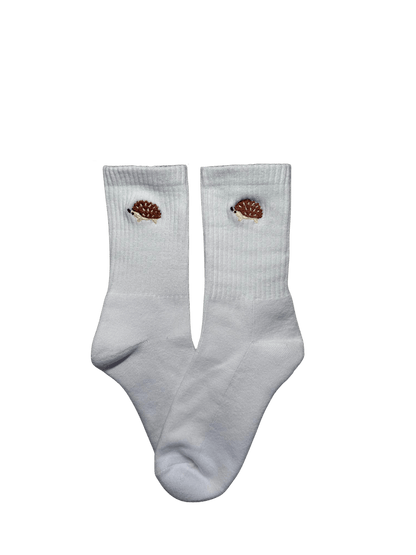 Chaussettes blanches hautes, 100% coton. Personnalisation des chaussettes grâce à des broderies. Il faut choisir parmi un choix de broderies dessinées à la main sur le thème de l’automne, saison automnale, Halloween, broderie cosy. La broderie est présente sur le côté extérieur des chaussettes. Toutes les broderies sont faites à la commande selon la personnalisation choisie. Ici, il s’agit de la broderie hérisson, marron, beige et noir. 