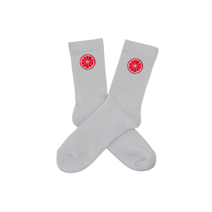 Chaussettes blanches hautes, 100% coton. Personnalisation des chaussettes grâce à des broderies. Il faut choisir parmi un choix de broderies dessinées à la main sur le thème de l’été sur la Côte d’Azur dans les Alpes Maritimes, 06. La broderie est présente sur le côté extérieur des chaussettes. Toutes les broderies sont faites à la commande selon la personnalisation choisie. Ici, il s’agit de la broderie pomelo, pamplemousse, agrume, rose flashy.