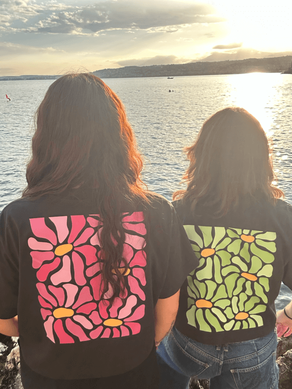 2 modèles femmes de dos au coucher de soleil face à la mer cote d'azur Nice . Personnalisation unique crop top flocage DTF fleur rose et verte