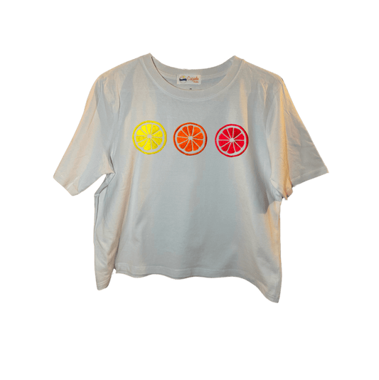 Crop top blanc, manche courte, large, 100% coton. Personnalisation du débardeur grâce à des broderies. Il faut choisir parmi un choix de broderies dessinées à la main sur le thème de l’été sur la Côte d’Azur dans les Alpes Maritimes, 06. Il faut aussi choisir la position de la broderie entre à gauche côté cœur, à droite ou au milieu. Toutes les broderies sont faites à la commande selon la personnalisation choisie. Ici, il s’agit de la broderie 3 agrumes : citron, orange et pomelo, pamplemousse rose flashy. 