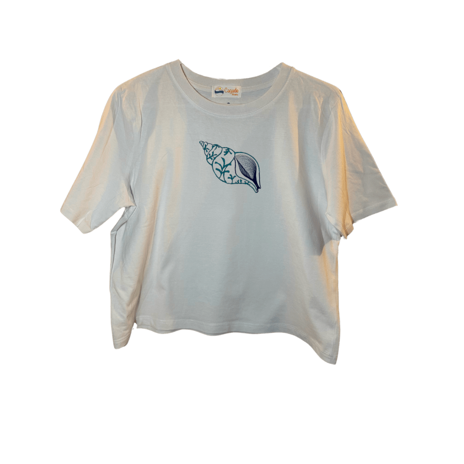 Crop top blanc, manche courte, large, 100% coton. Personnalisation du débardeur grâce à des broderies. Il faut choisir parmi un choix de broderies dessinées à la main sur le thème de l’été sur la Côte d’Azur dans les Alpes Maritimes, 06. Il faut aussi choisir la position de la broderie entre à gauche côté cœur, à droite ou au milieu. Toutes les broderies sont faites à la commande selon la personnalisation choisie. Ici, il s’agit de la broderie coquillage en spirale bleu.