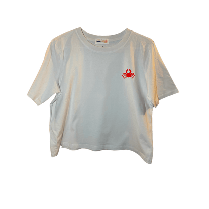 Crop top blanc, manche courte, large, 100% coton. Personnalisation du débardeur grâce à des broderies. Il faut choisir parmi un choix de broderies dessinées à la main sur le thème de l’été sur la Côte d’Azur dans les Alpes Maritimes, 06. Il faut aussi choisir la position de la broderie entre à gauche côté cœur, à droite ou au milieu. Toutes les broderies sont faites à la commande selon la personnalisation choisie. Ici, il s’agit de la broderie crabe rouge.