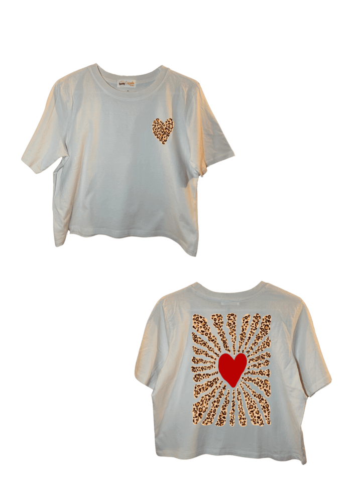 Crop top blanc court, manche courte, 100% coton. Personnalisation du crop top grâce à une technique de flocage, le DTF, pour une meilleure qualité d’impression et de tenue. La personnalisation est floquée à l’avant au niveau du cœur, un coeur léopard en haut à gauche et à l’arrière en grand dans le dos coeur rouge plus léopard. Ici, il s’agit de la personnalisation de DTF cœur rouge et vague léopard autour. 