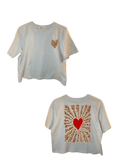 Crop top blanc court, manche courte, 100% coton. Personnalisation du crop top grâce à une technique de flocage, le DTF, pour une meilleure qualité d’impression et de tenue. La personnalisation est floquée à l’avant au niveau du cœur, un coeur léopard en haut à gauche et à l’arrière en grand dans le dos coeur rouge plus léopard. Ici, il s’agit de la personnalisation de DTF cœur rouge et vague léopard autour. 