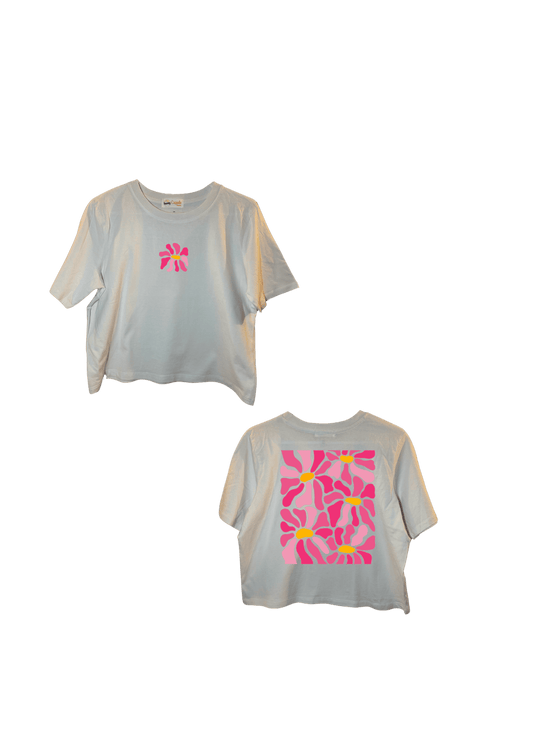 Crop top blanc court, manche courte, 100% coton. Personnalisation du crop top grâce à une technique de flocage, le DTF, pour une meilleure qualité d’impression et de tenue. La personnalisation est floquée à l’avant au milieu en haut et à l’arrière en grand dans le dos. Ici, il s’agit de la personnalisation de DTF fleur rose. 