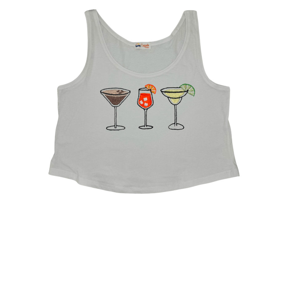 Débardeur blanc court, crop top, 100% coton. Personnalisation du débardeur grâce à des broderies. Il faut choisir parmi un choix de broderies dessinées à la main sur le thème de l’été sur la Côte d’Azur dans les Alpes Maritimes, 06. Il faut aussi choisir la position de la broderie entre à gauche côté cœur, à droite ou au milieu. Toutes les broderies sont faites à la commande selon la personnalisation choisie. Ici, il s’agit de la broderie 3 cocktails : espresso martini, Aperol spritz et margarita. 