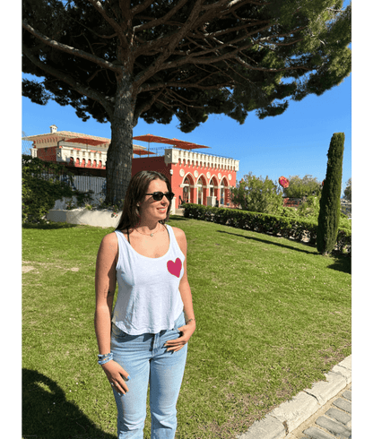 Mannequin femme portant un débardeur blanc avec personnalisation flocage DTF coeur rose. Chateau Nice 06 été soleil