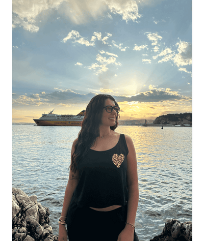 Mannequin modèle femme portant un débardeur noir court en coton avec personnalisation flocage DTF coeur léopard. Plage mer été coucher de soleil lunettes Nice 06