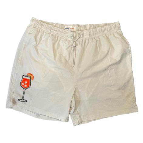 Maillot de plage pour homme couleur beige. Personnalisation du maillot grâce à des broderies. Il faut choisir parmi un choix de broderies dessinées à la main sur le thème de l’été sur la Côte d’Azur dans les Alpes Maritimes, 06. La broderie est brodée sur l’avant du maillot, jambe droite. Toutes les broderies sont faites à la commande selon la personnalisation choisie. Ici, il s’agit de la broderie Aperol spritz, cocktail, summer.