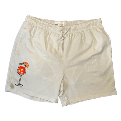 Maillot de plage pour homme couleur beige. Personnalisation du maillot grâce à des broderies. Il faut choisir parmi un choix de broderies dessinées à la main sur le thème de l’été sur la Côte d’Azur dans les Alpes Maritimes, 06. La broderie est brodée sur l’avant du maillot, jambe droite. Toutes les broderies sont faites à la commande selon la personnalisation choisie. Ici, il s’agit de la broderie Aperol spritz, cocktail, summer.