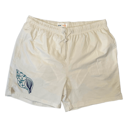 Maillot de plage pour homme couleur beige. Personnalisation du maillot grâce à des broderies. Il faut choisir parmi un choix de broderies dessinées à la main sur le thème de l’été sur la Côte d’Azur dans les Alpes Maritimes, 06. La broderie est brodée sur l’avant du maillot, jambe droite. Toutes les broderies sont faites à la commande selon la personnalisation choisie. Ici, il s’agit de la broderie coquillage bleu spirale.