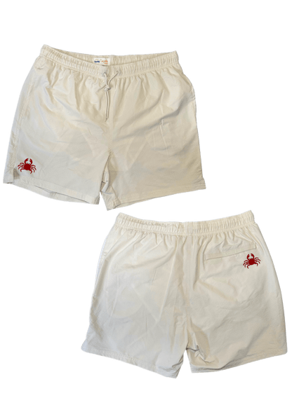 Maillot de plage pour homme couleur beige. Personnalisation du maillot grâce à des broderies. Il faut choisir parmi un choix de broderies dessinées à la main sur le thème de l’été sur la Côte d’Azur dans les Alpes Maritimes, 06. La broderie est brodée sur l’avant du maillot, jambe droite et sur la poche arrière jambe droite. Toutes les broderies sont faites à la commande selon la personnalisation choisie. Ici, il s’agit de la broderie crabe, rouge.